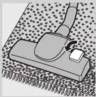 Illustration of a hand operating a small object on a textured surface (no text or symbols).