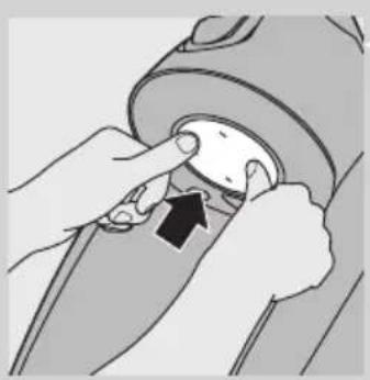 Close-up of hands adjusting a mechanical component with an arrow indicating rotation.