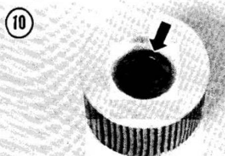 Close-up of a circular mechanical part with a dark central hole and an arrow pointing to it, no visible text or symbols.