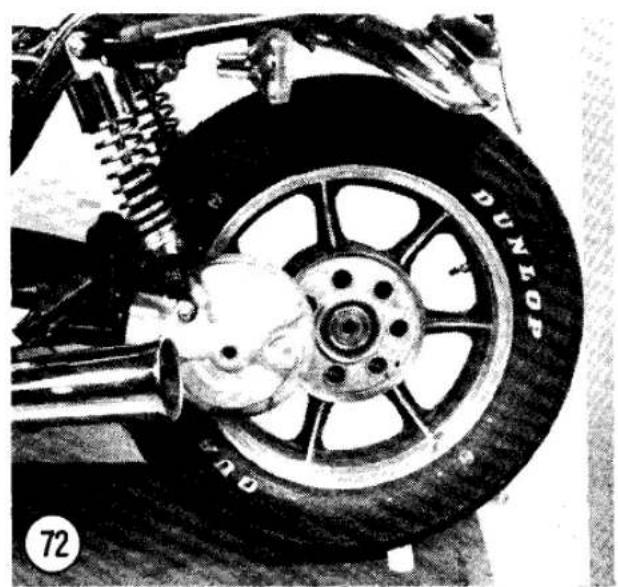 Close-up of a motorcycle's wheel and suspension system, showing tire and brake components (no readable text or symbols)