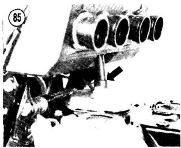 Close-up of a mechanical device with multiple cylindrical components and a black arrow pointing to a component (no visible text or symbols)