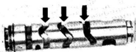 Mechanical component diagram showing internal parts with downward arrows indicating motion or force (no text or symbols)