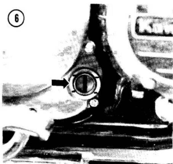 Close-up of a mechanical component with a circular opening and an arrow pointing to it, no visible text or symbols.