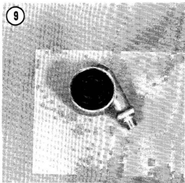 Top-down view of a dark circular object with a pointed tip, placed on a textured surface (no visible text or symbols)
