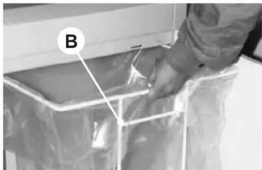Person handling a plastic bag in a container labeled B (no visible text or symbols)