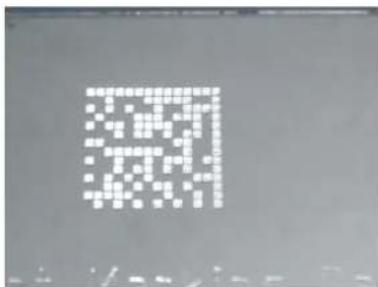 Pixelated QR code on a dark background, likely for scanning to access digital content or a URL.