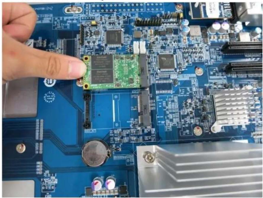 Close-up of a hand adjusting a small electronic component on a blue printed circuit board (no visible text or symbols)