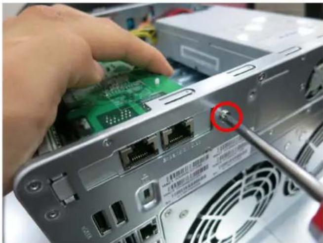 Close-up of a hand inserting a green circuit board into a server rack with a screwdriver inserted (no visible text or symbols)