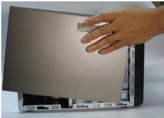 Hand pressing down on a laptop keyboard with a textured screen (no visible text or symbols)