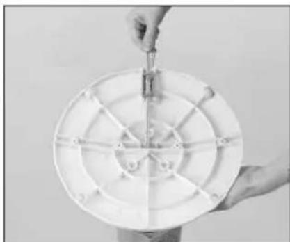 Person holding a small tool interacting with a circular mechanical component (no visible text or symbols)