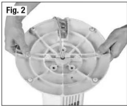 Close-up of hands installing or adjusting a circular mechanical component with radial lines and mounting holes (no text or symbols visible)