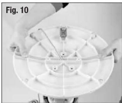 Close-up of hands holding a circular mechanical component with radial slots and a central hub (no text or symbols visible)