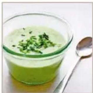 Bowl of green creamy soup with chopped green herbs, accompanied by a spoon (no text or symbols visible)
