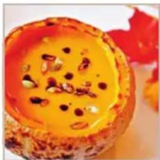 Close-up of a baked dessert with orange sauce and visible seeds (no text or symbols)