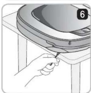Illustration of a hand using a tool to adjust or install a large circular object on a table (no text or symbols visible).