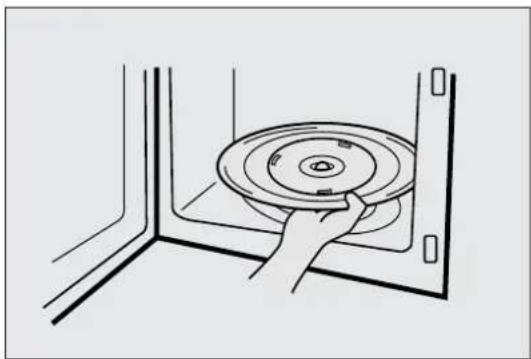 Line drawing of a hand holding a circular component mounted inside a corner frame (no text or symbols)