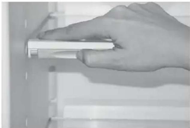 Hand holding a white cylindrical object against a plain background (no text or symbols visible)
