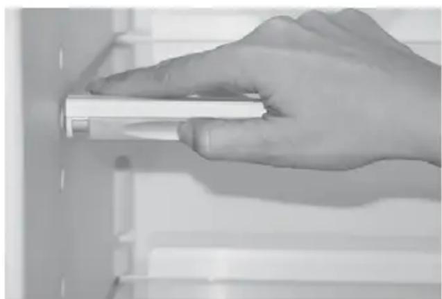 Hand holding a cylindrical object against a plain background (no text or symbols visible)
