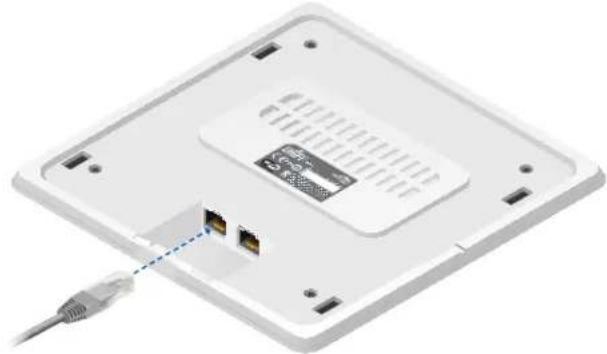 Exterior view of a white electronic device rear panel with two ports and a connector, showing no visible text or symbols.