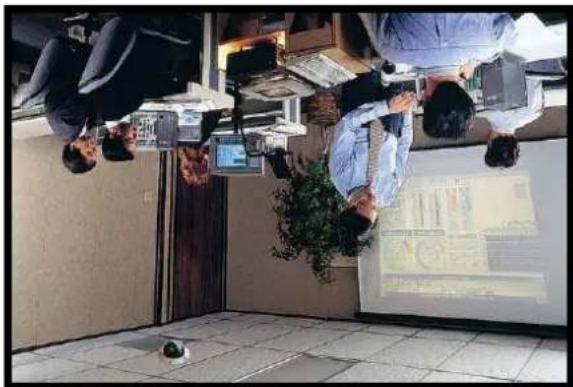 Overhead view of office workers in uniform seated on a bench, viewed from above; no visible text or symbols.