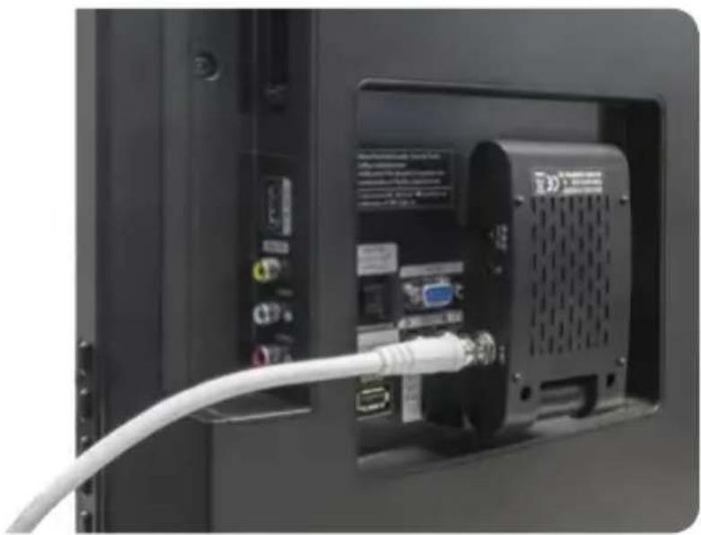Back view of a black computer monitor with an attached white cable showing the cable (no visible text or symbols)