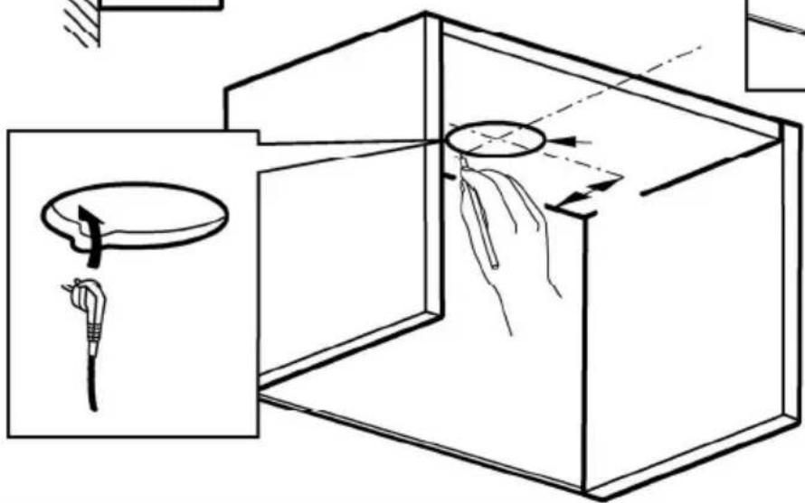 Diagram of a hand holding a tool inside a box, showing a circular component being inserted into it (no text or symbols present)