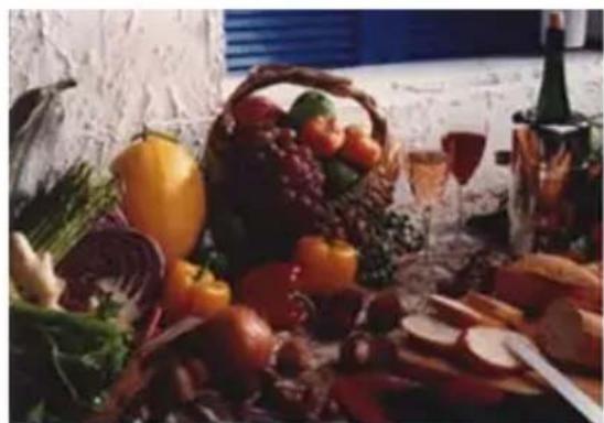 Still life arrangement of assorted fresh vegetables and fruits including a basket, wine bottle, and glass (no text or symbols visible)