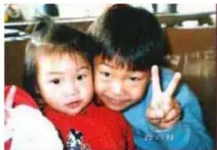 Two children making peace signs together (no visible text or symbols)