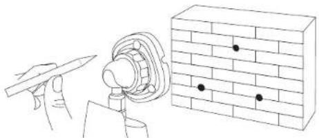 Line drawing of a hand holding a pencil next to a brick wall with four black dots (no text or symbols)