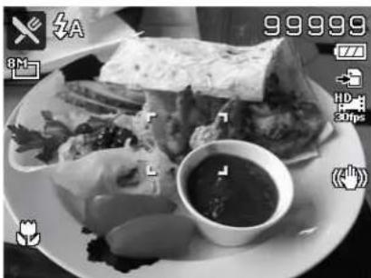Black-and-white photo of a plated dish with meat, vegetables, and a small bowl containing sauce (no visible text or symbols)