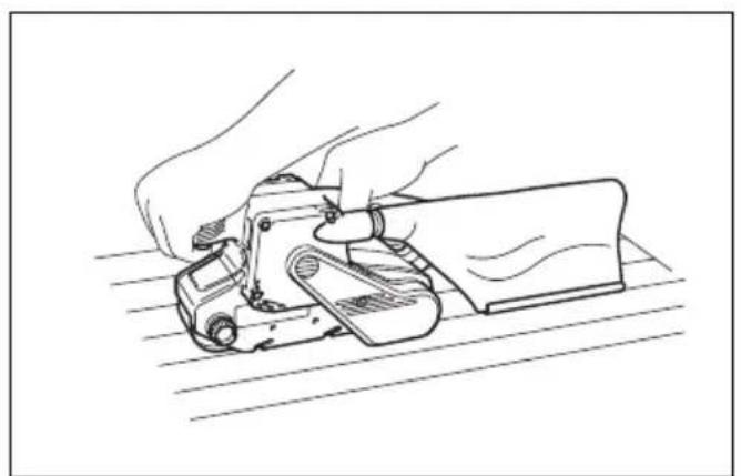 Line drawing of a hand using a manual tool to cut or install a component on a flat surface (no text or symbols)