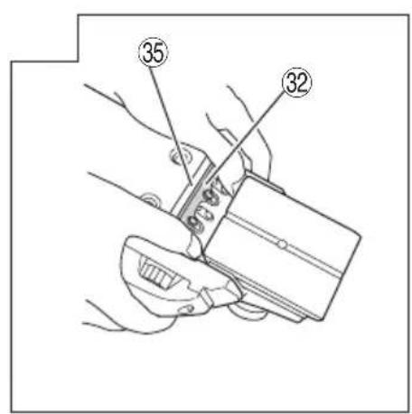 Technical diagram showing a hand holding a tool with labeled parts 32 and 35