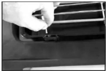 Close-up of a hand holding a small object against a car grille (no visible text or symbols)