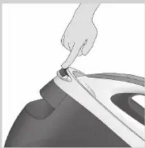 Close-up of a hand pressing down on a small object, possibly a iron or iron piece, with no visible text or symbols.