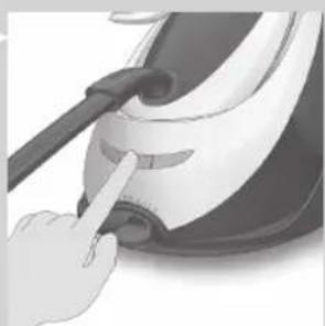 Close-up of a hand pressing down on a small white object with a brush (no text or symbols visible)