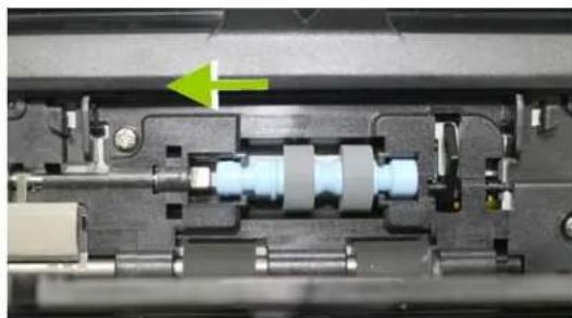 Close-up mechanical assembly showing internal components and a green arrow indicating direction (no text or symbols)