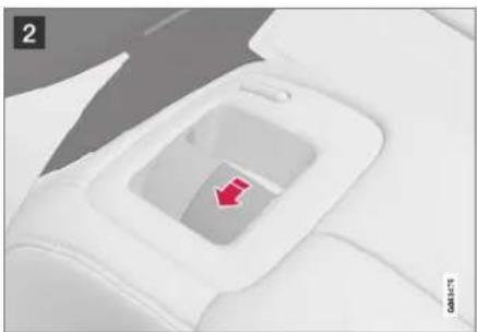 Close-up of a white car interior with a red arrow pointing to the center area (no text or symbols visible)