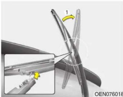 Close-up of a mechanical component with a yellow arrow indicating direction, showing a close-up view of a curved tool or bracket (no text or symbols visible)