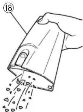 Hand holding a mechanical device with particles being poured into it (no text or symbols visible)