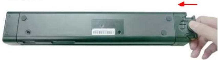 Hand holding a green remote control box with a red arrow pointing to the right side (no text or symbols visible)