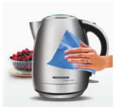 Hand cleaning a blue cloth on a stainless steel kettle, with berries in the background (no text or symbols visible)