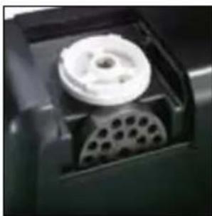 Close-up of a mechanical component with a circular housing and perforated base (no visible text or symbols)