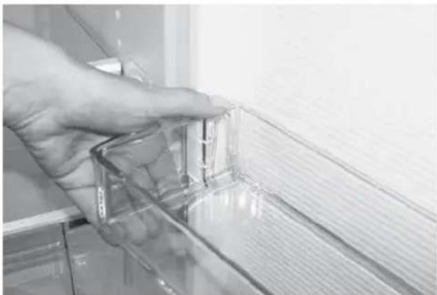 Close-up of a hand adjusting a transparent plastic door panel (no text or symbols visible)
