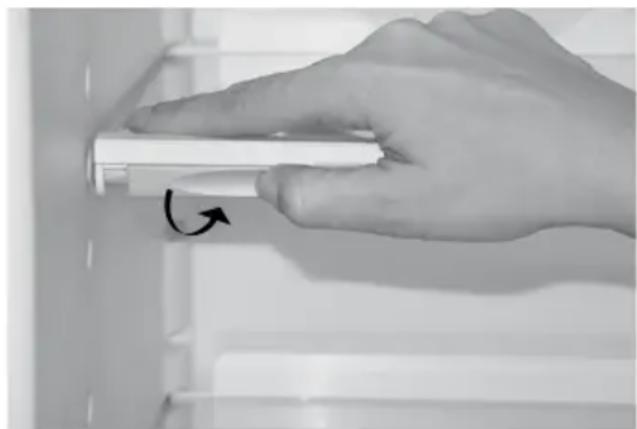 Hand holding a white cylindrical object with an arrow indicating rotation (no text or symbols visible)