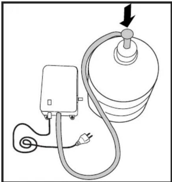 Diagram of a medical or electrical device connected to a cylindrical device with a plug, showing wiring and a downward arrow.