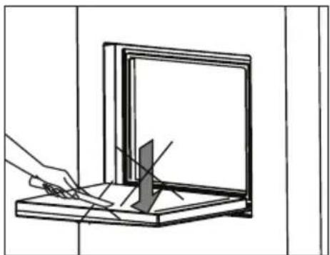 Line drawing of a hand using a pen to cut a rectangular object on a wooden base, with no visible text or symbols.
