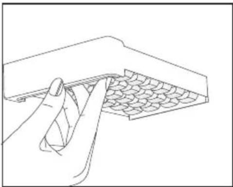 Line drawing of a hand inserting a spring into a tray with patterned contents.