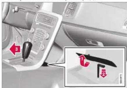 Car interior control panel with red directional arrows and a magnified inset showing a device labeled '1' and '2' with text 'GAR187'