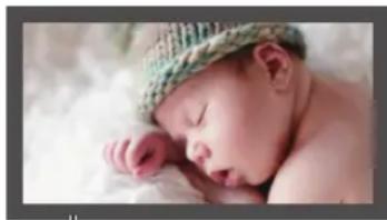 Newborn baby wearing a knitted hat, resting her head on her hand (no text or symbols visible)
