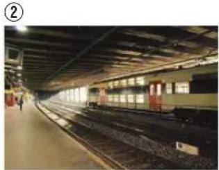 Interior view of a train station platform with multiple tracks and illuminated windows (no visible text or signage)
